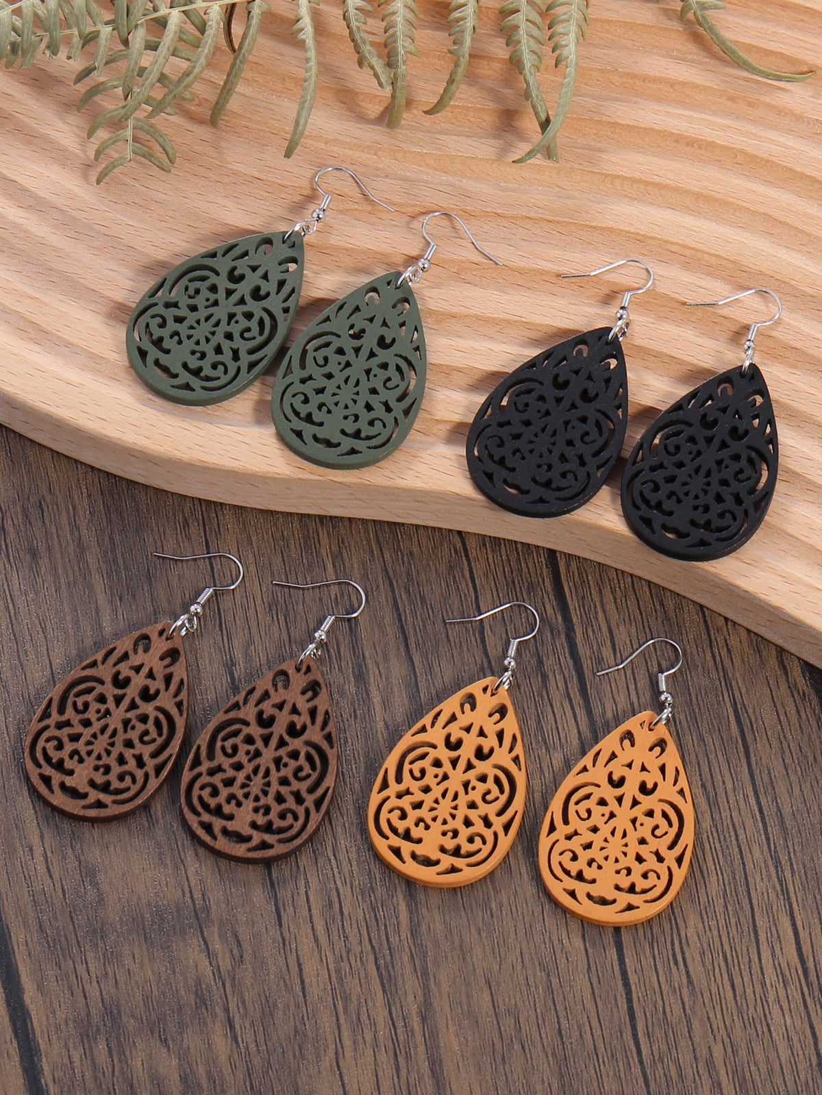 A Set Of Wooden Earrings Includes Four Pairs In Black, Brown,  Green, And Yellow.